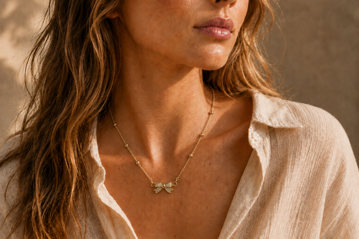 Collier Nœud Lumière – Chaîne dorée perlée & pendentif nœud scintillant