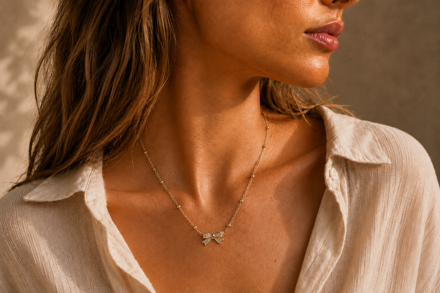 Collier Nœud Lumière – Chaîne dorée perlée & pendentif nœud scintillant