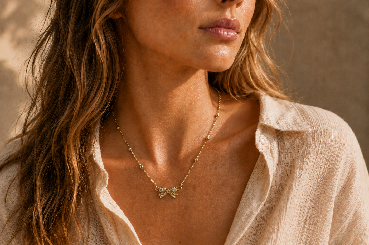 Collier Nœud Lumière – Chaîne dorée perlée & pendentif nœud scintillant