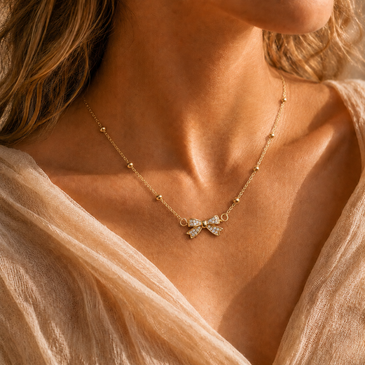 Collier Nœud Lumière – Chaîne dorée perlée & pendentif nœud scintillant