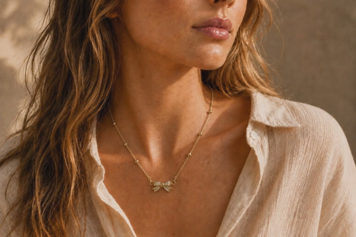 Collier Nœud Lumière – Chaîne dorée perlée & pendentif nœud scintillant
